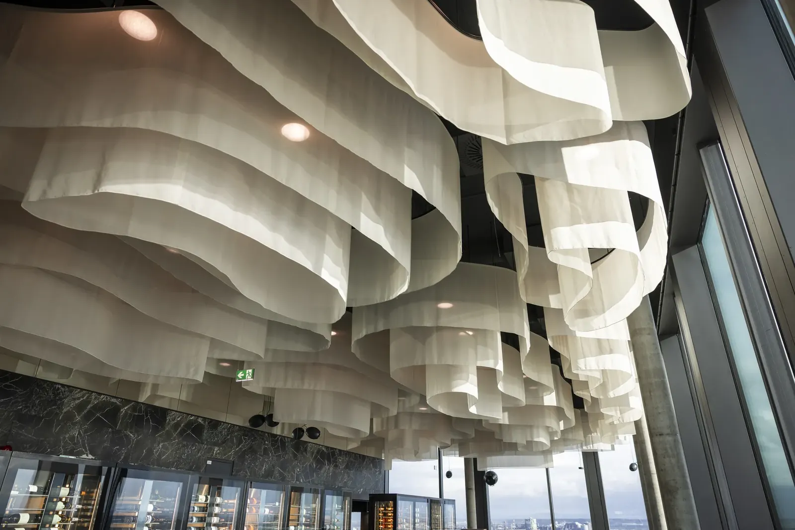 Wolkendekoration aus hellem Stoff unter der Decke im ARCOTEL Tabakfabrik Linz